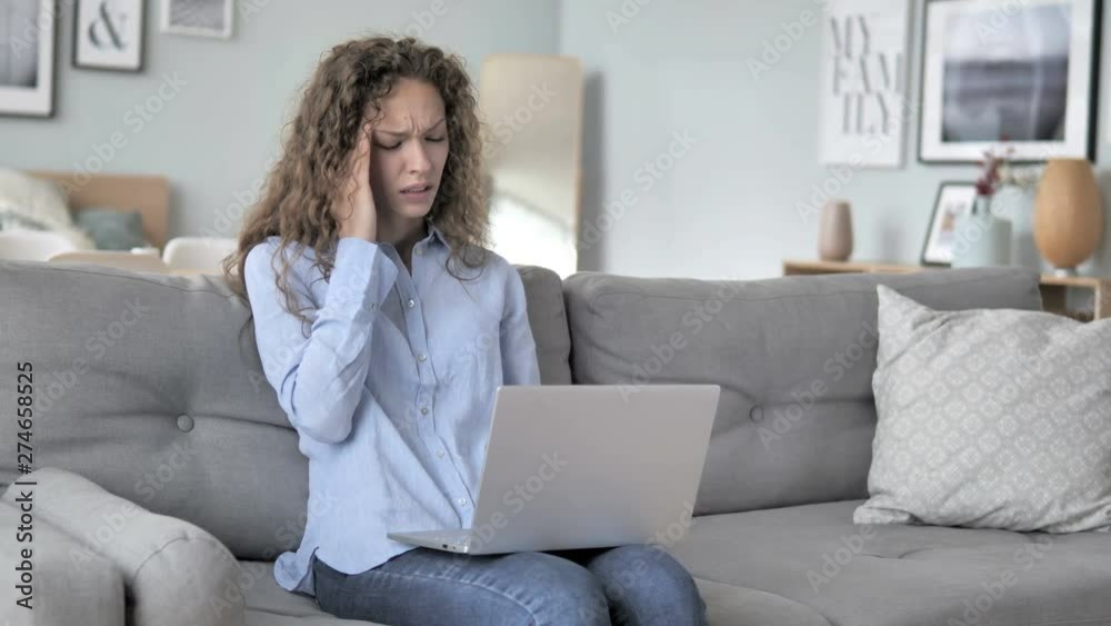 Curly Hair Woman with Headache Working on Laptop while Sitting on Couch Curly Hair Woman with Headache Working on Laptop while Sitting on Couch