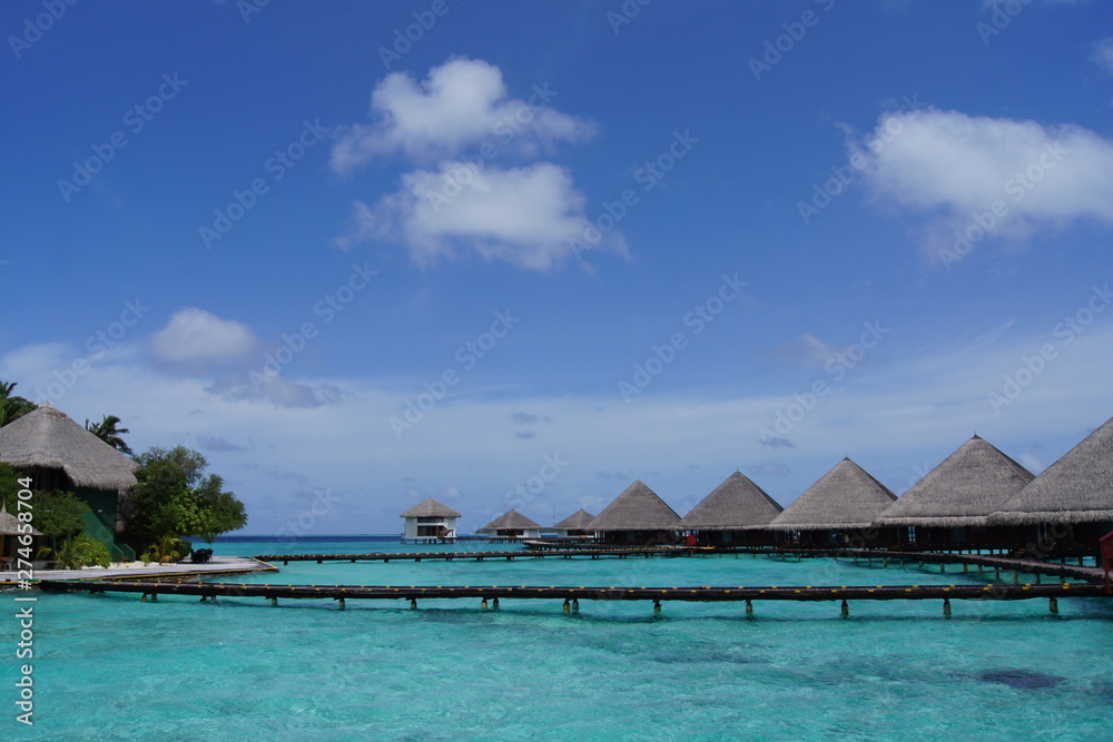 Water villas, sky and turquoise ocean on a clear sunny day