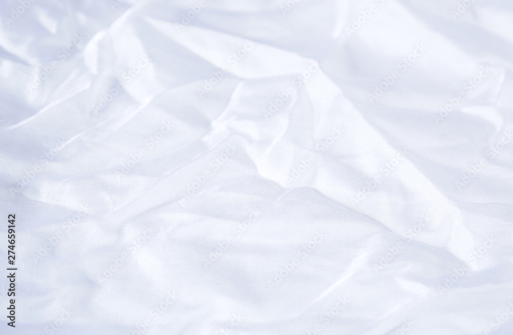 Fototapeta premium Textile and textural concept - close up of crumpled white silk wavy fabric background with copy space for text or image