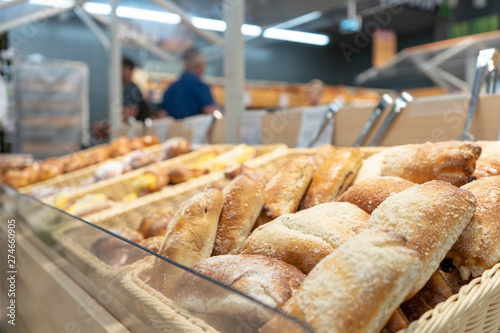 Close-up. Freshly baked buns in a wicker basket on a shop window in the supermarket waiting for the buyer