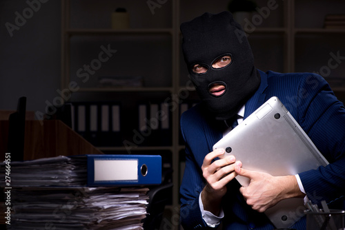 Male employee stealing information in the office night time  