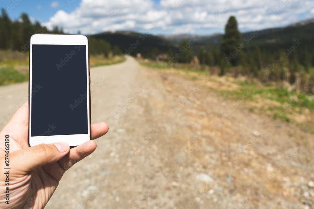 man holding phone on the road