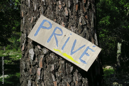 Panneau marqué Privé sur le tronc d'un arbre.