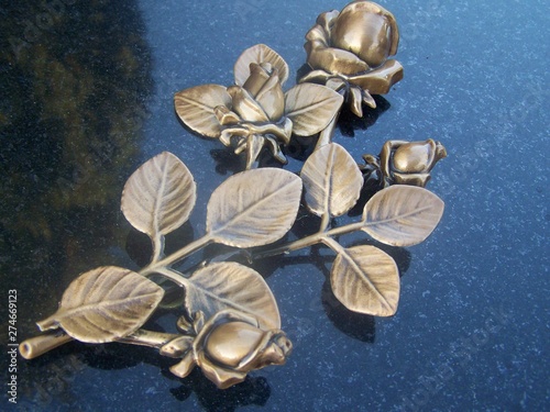 złote zdobienia w formie kwiatów i liści na nagrobku