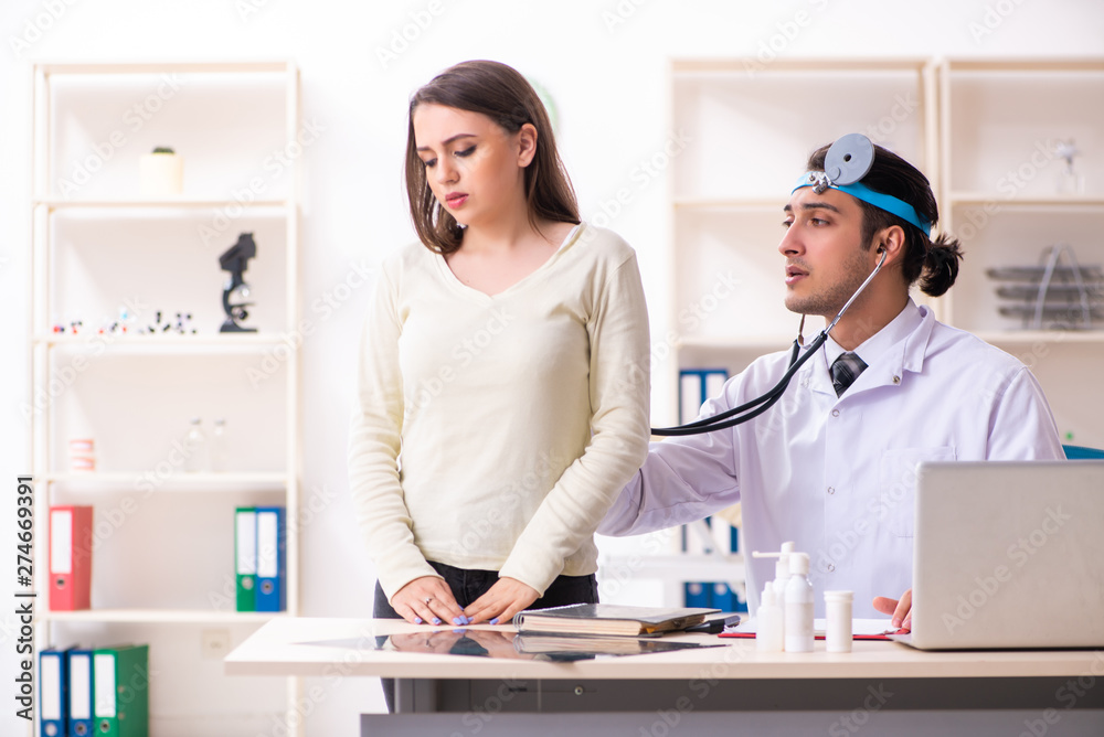 Fototapeta premium Young male doctor and female beautiful patient