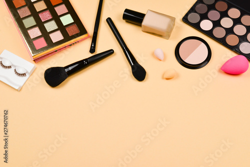 Professional trendy makeup products with cosmetic beauty products, foundation, lipstick, eye shadows, eye lashes, brushes and tools.