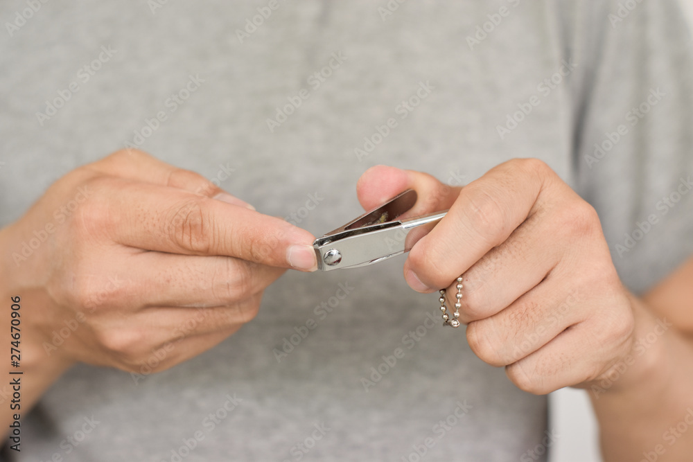 Man cutting nails using nail clipper, close-up Man cutting nails using nail clipper, close-up