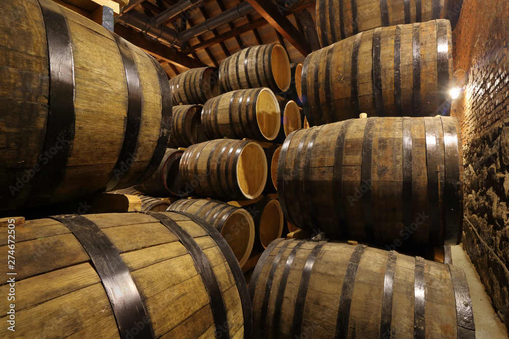 Rows of alcohol barrels in stock. Distillery. Cognac, whiskey, wine, brandy. Alcohol in barrels Rows of alcohol barrels in stock. Distillery. Cognac, whiskey, wine, brandy. Alcohol in barrels