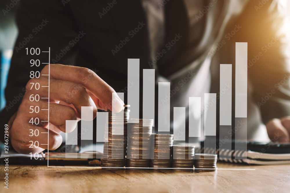 Business accountant working on desk using mobile phone and calculator to calculate budget concept finance and accounting in morning light Business accountant working on desk using mobile phone and calculator to calculate budget concept finance and accounting in morning light