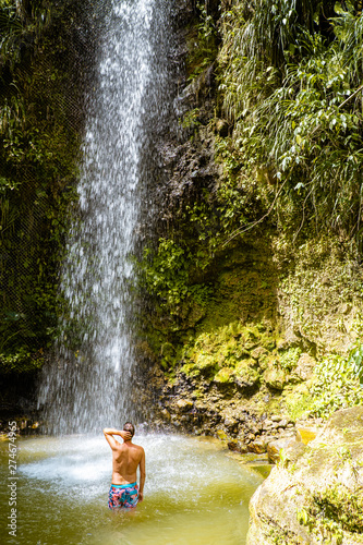 young men posing at Toraille waterfall St Lucia. Saint Lucia jungle with waterfall and men swimming photo