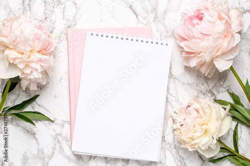 Beautiful white peony flower and notebook on marble background