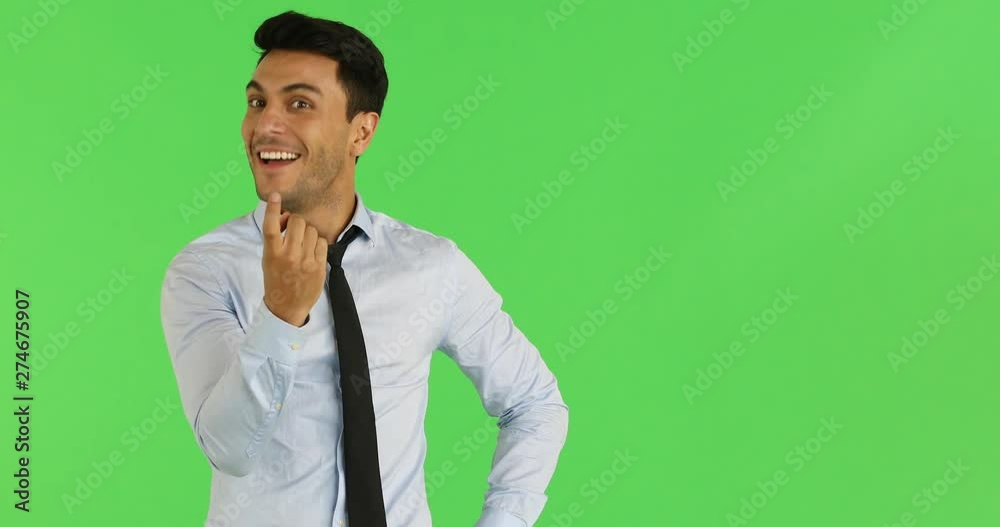 Happy handsome Caucasian businessman smiling and beckon his finger isolated on green background. Happy handsome Caucasian businessman smiling and beckon his finger isolated on green background.