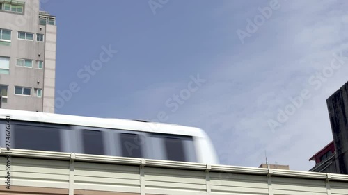 Low angle view as a city passenger train passes left to right on an elevated track system.with copy space for text 