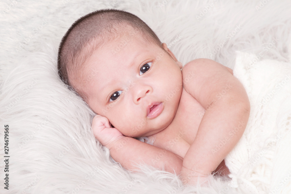Adorable asian newborn baby in wrap sleeping on white blanket background. Portrait of newborn boy sleep on bed. open eyes. Adorable asian newborn baby in wrap sleeping on white blanket background. Portrait of newborn boy sleep on bed. open eyes.