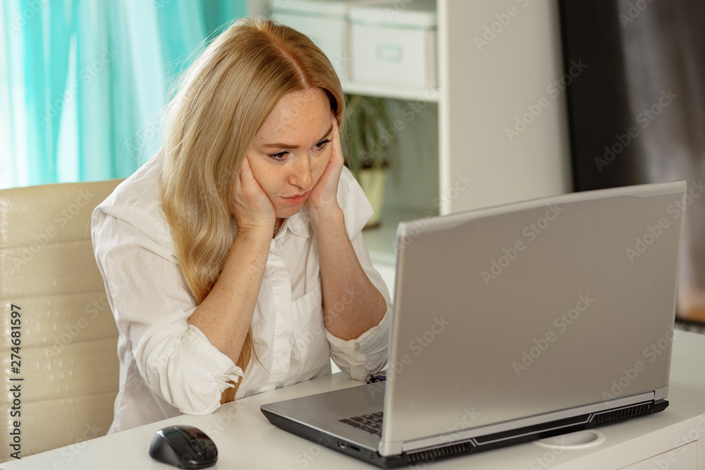 Bored young woman sit at home office table look in distance unable to work at laptop, exhausted girl student feel unmotivated unwilling to study, distracted taking break. Dull monotonous job concept