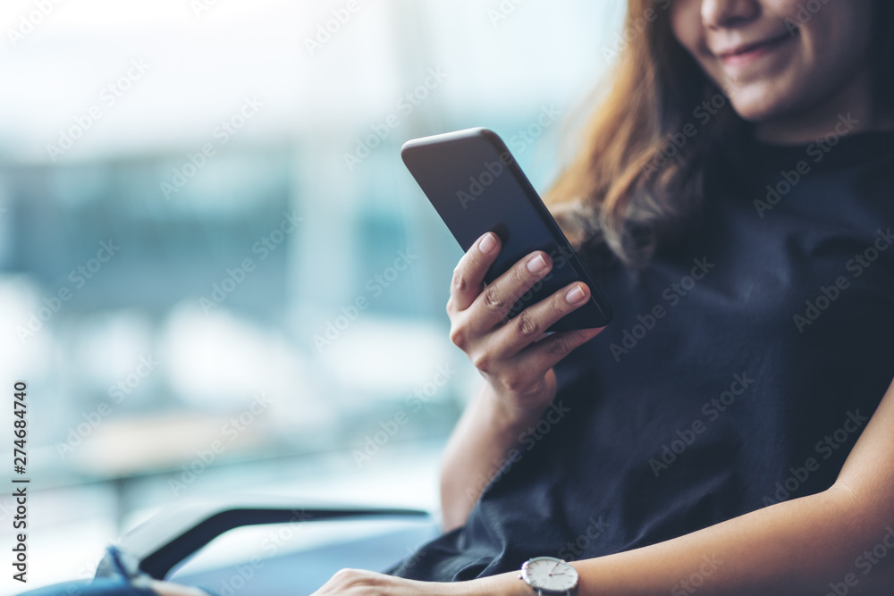 A woman traveler using mobile phone while sitting in the airport A woman traveler using mobile phone while sitting in the airport
