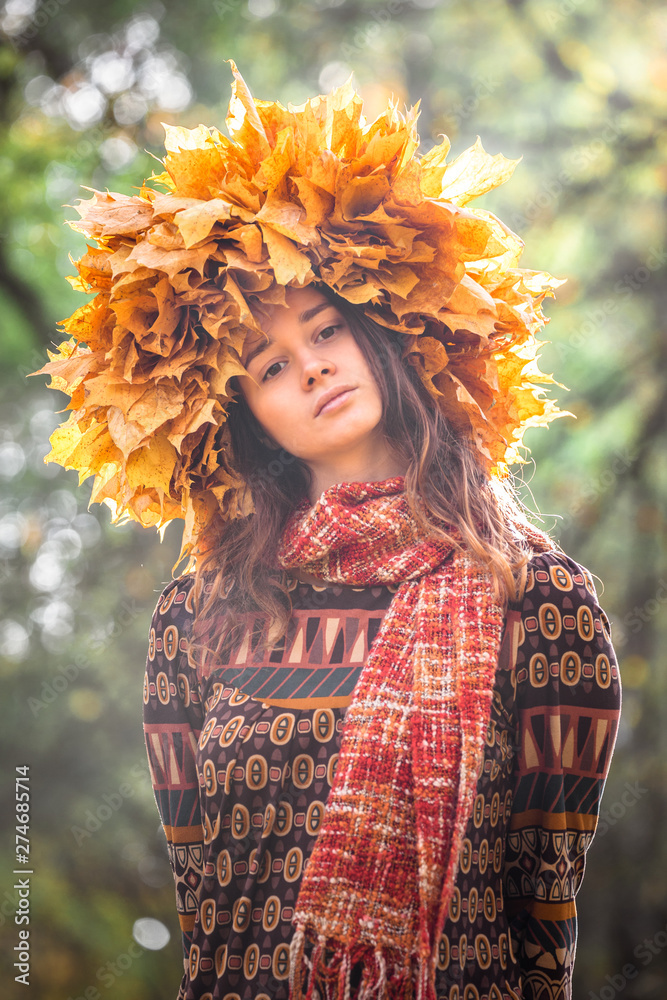 Young smiling woman with wreath of maple leaves on a head, outdoor portrait in autumn park Young smiling woman with wreath of maple leaves on a head, outdoor portrait in autumn park