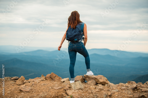 A healthy woman celebrates during a beautiful sunset. Happy and free. stand on the edge of the mountain. beautiful mountain.