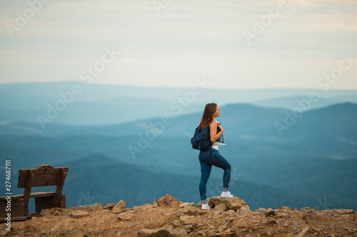 A healthy woman celebrates during a beautiful sunset. Happy and free. stand on the edge of the mountain. beautiful mountain.