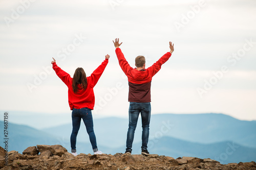 romantic couple in love standing together on a mountain at sunset beach, silhouettes young man and woman on holidays or honeymoon. shop on the mountain