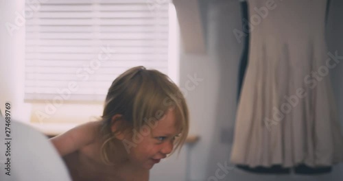 Happy little toddler taking off his diaper to use the toilet