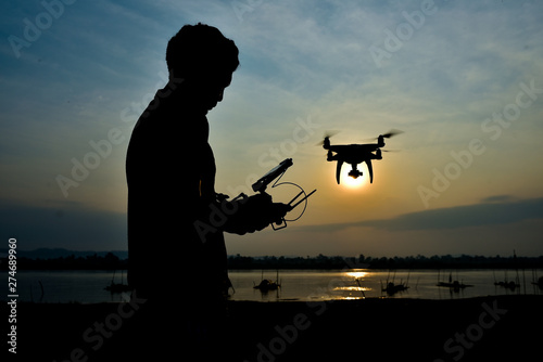 Men during control joy stick drones to take pictures of the sunset. © AlexPhototest