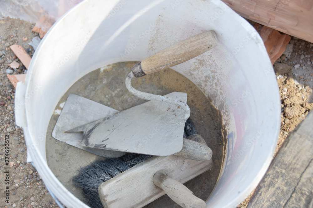 trowel and brush in an old white bucket trowel and brush in an old white bucket