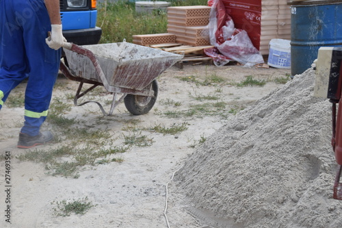 wheelbarrow with concrete run by a bricklayer