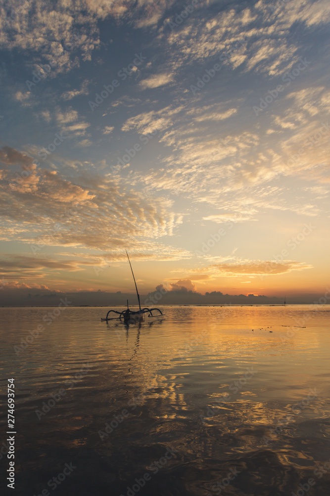 Sunrise view at Sanur Beach, Bali island, Indonesia. Traditional Balinese jukung fishing boats in the port Sunrise view at Sanur Beach, Bali island, Indonesia. Traditional Balinese jukung fishing boats in the port