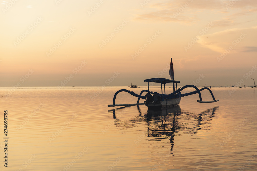 Sunrise view at Sanur Beach, Bali island, Indonesia. Traditional Balinese jukung fishing boats