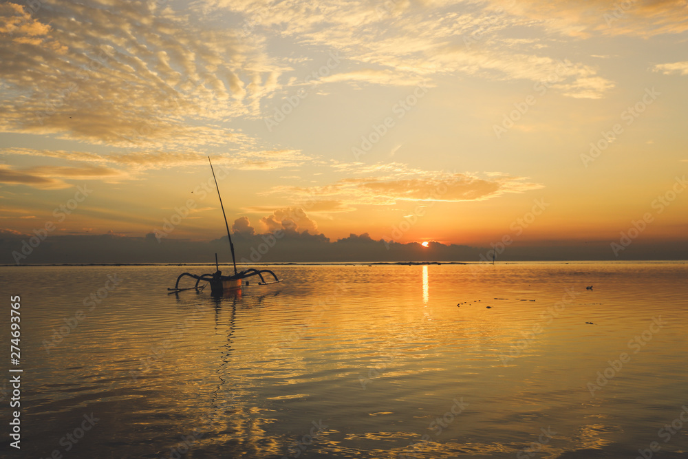 Sunrise view at Sanur Beach, Bali island, Indonesia. Traditional Balinese jukung fishing boats