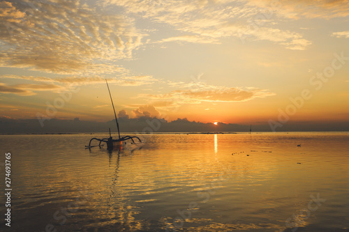 Sunrise view at Sanur Beach, Bali island, Indonesia. Traditional Balinese jukung fishing boats © minjan
