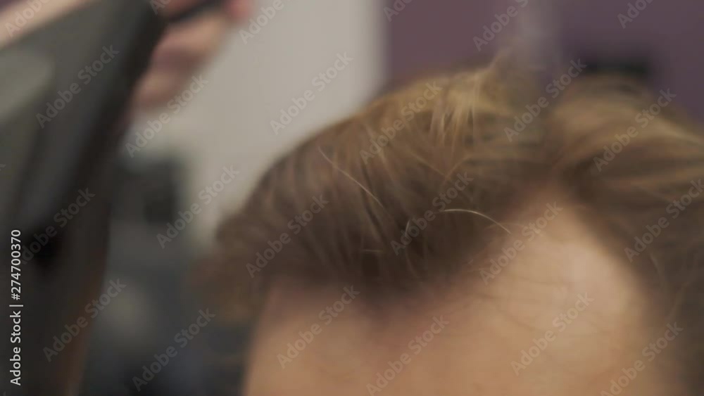 the guy put his hair in a hair dryer.slow motion the guy put his hair in a hair dryer.slow motion