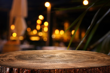 background of wooden table in front of abstract blurred restaurant lights