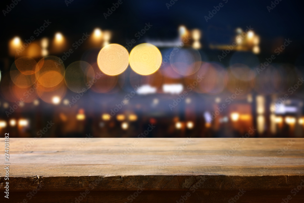 background of wooden table in front of abstract blurred restaurant lights