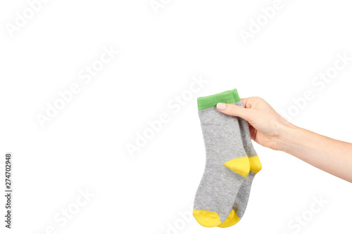 Hand with warm winter childrens socks, cute cotton clothes