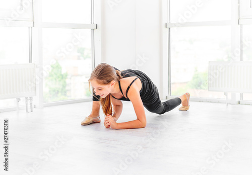 Teen girl stretching in exercise room