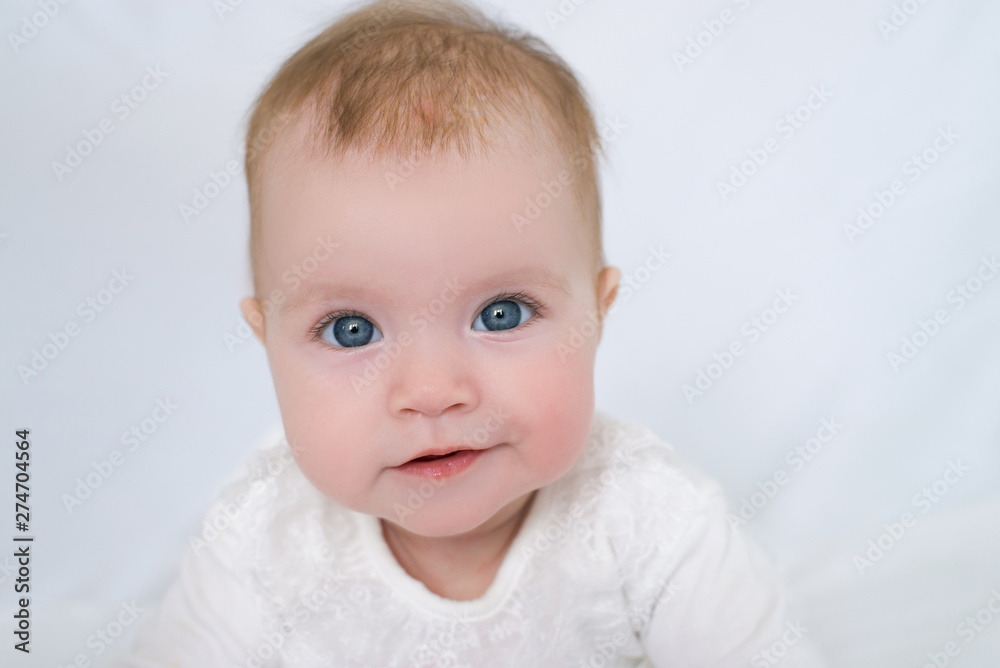large portrait of little girl with blue eyes in white dress on white background, little girl looking at camera