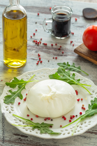 Burrata, Italian cheese with tomatoes, spices, argugula and olive oil and balsamic vinegar