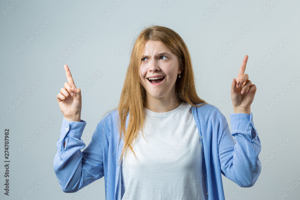 Emotional portrait of a red-haired girl on a gray background, stormy emotions, business concept. Emotional portrait of a red-haired girl on a gray background, stormy emotions, business concept.