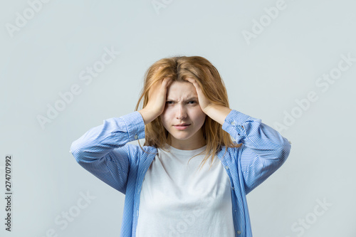 Emotional portrait of a red-haired girl on a gray background, stormy emotions, business concept. 