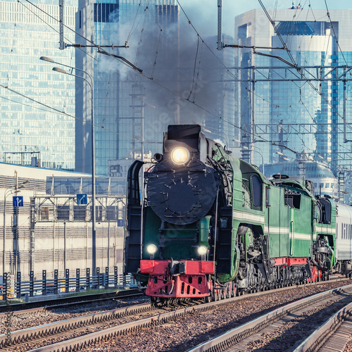 Retro steam train on Moscow city background. Russia.