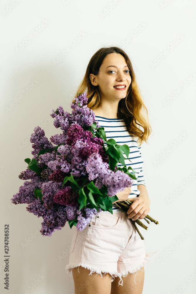 Attractive girl with a violet bouquet of lilac on a white background Attractive girl with a violet bouquet of lilac on a white background