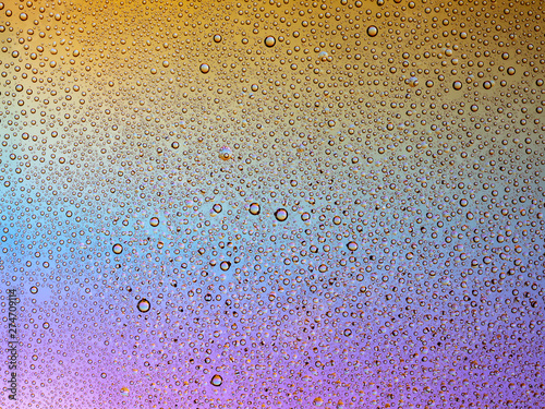 Water droplets on the glass with a colored background. Drops of water.