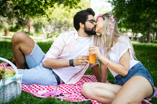 Happy couple on vacation. Lovers enjoy each other in the park, picnic
