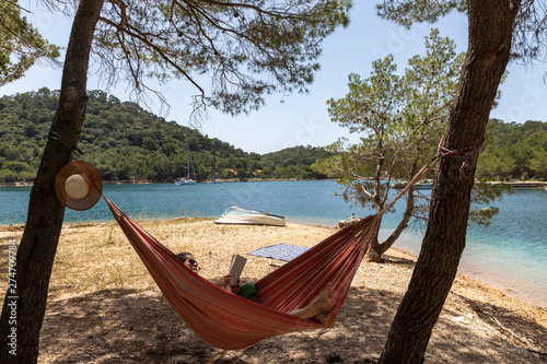 Obraz na płótnie Woman relaxing in the hammock on a hot sunny day on the island lastovo, croatia w salonie