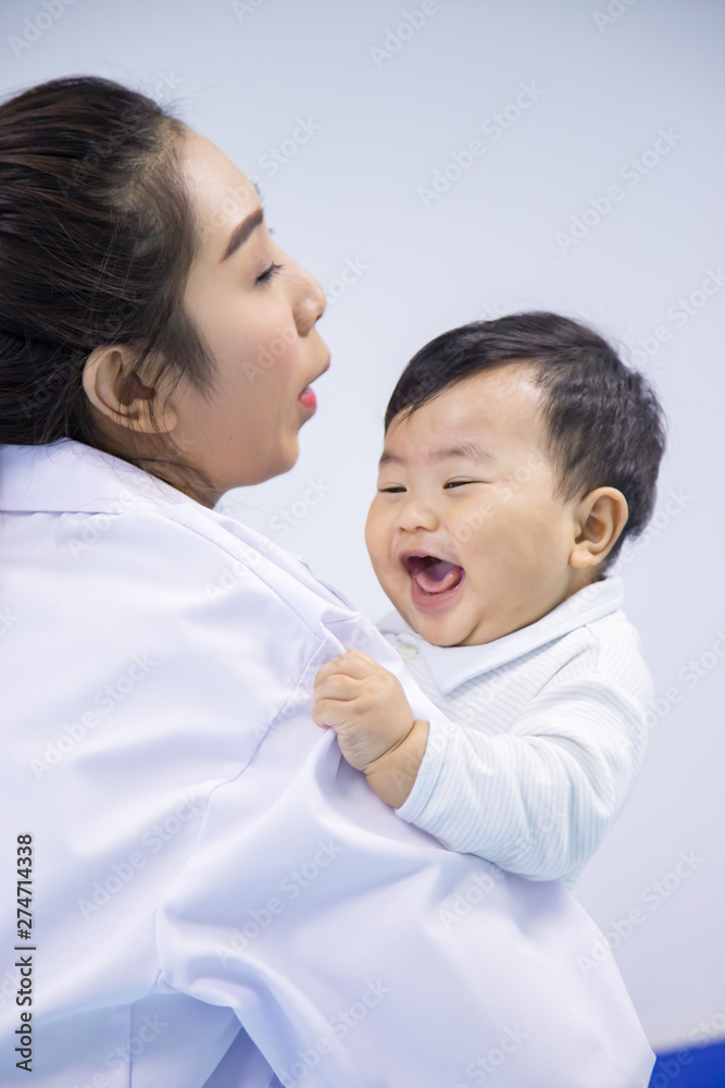 Doctor happy to little boy.medicine, healtcare, pediatry and people concept - happy doctor or pediatrician holding baby. Doctor happy to little boy.medicine, healtcare, pediatry and people concept - happy doctor or pediatrician holding baby.
