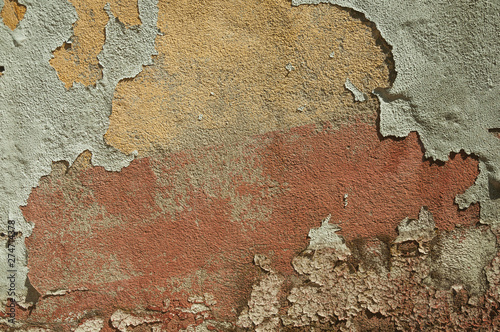 Worn wall with plaster covered by peeled paint