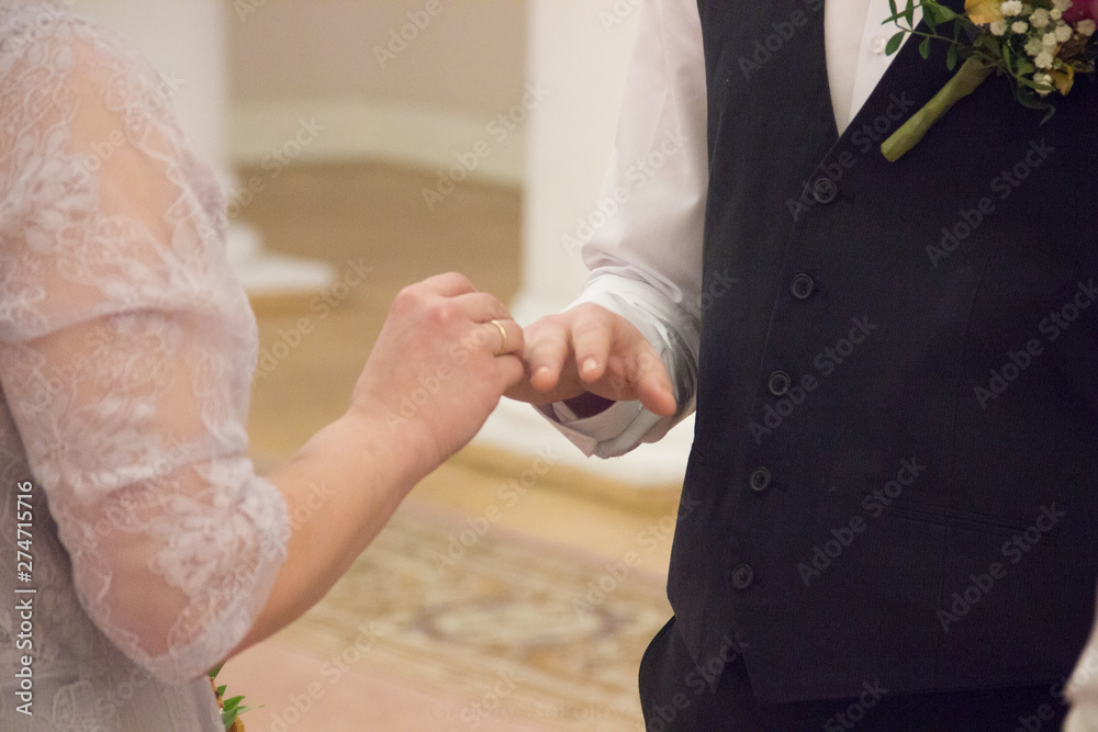 The bride puts a ring on the groom