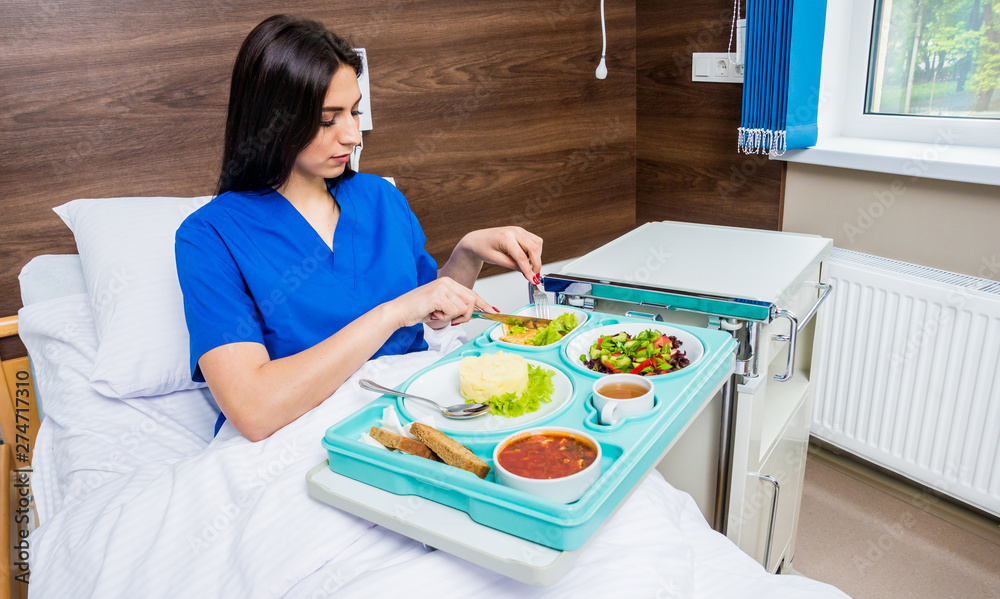 Tray with breakfast for the young female patient. The young woman eating in the hospital. Tray with breakfast for the young female patient. The young woman eating in the hospital.